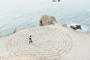TAP IN wellness journal dispels myths about meditation while a person walks a maze on the beach.